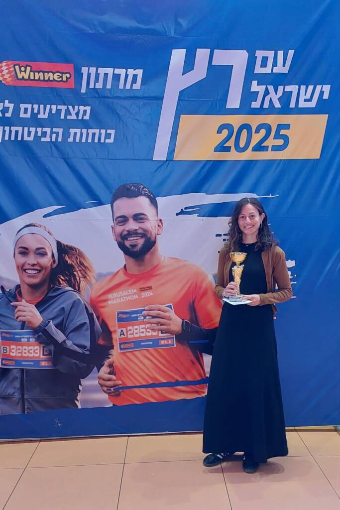 Chaya is holding a trophy after completing a marathon.