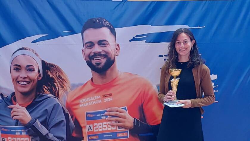 Chaya is holding a trophy after completing a marathon.