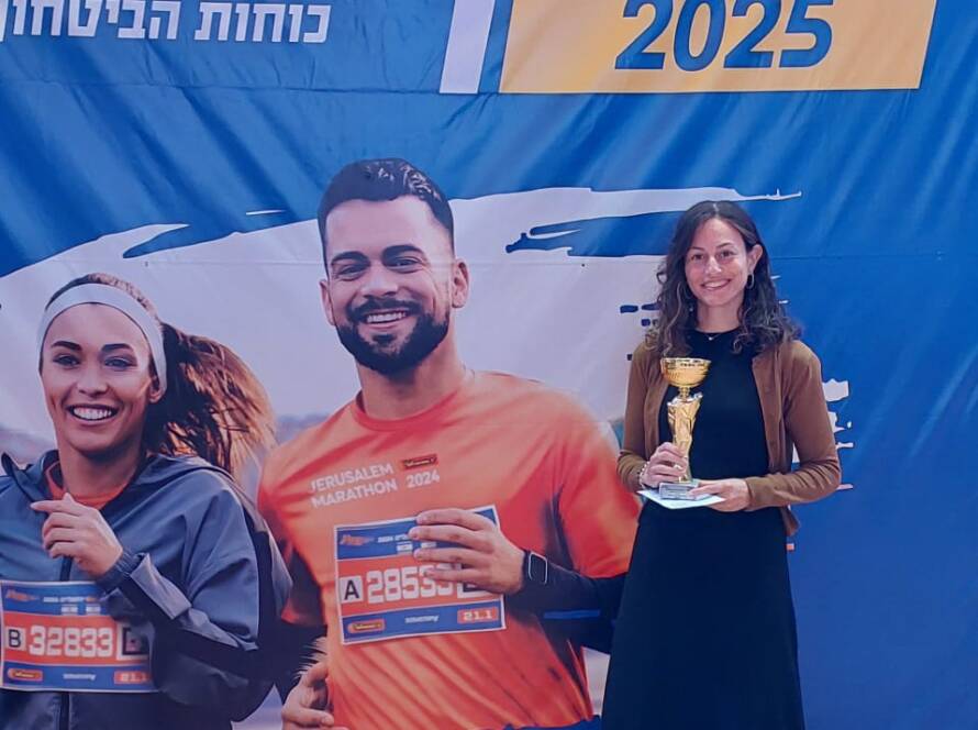 Chaya is holding a trophy after completing a marathon.