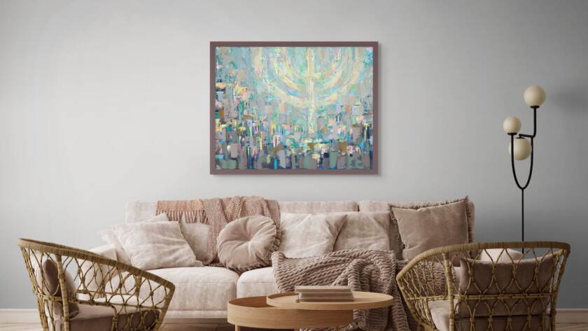 Painting of Jerusalem beneath a softly glowing floating menorah in pastel colors, hanging above a cream-colored sofa with wooden chairs and a wood coffee table in a modern living room.