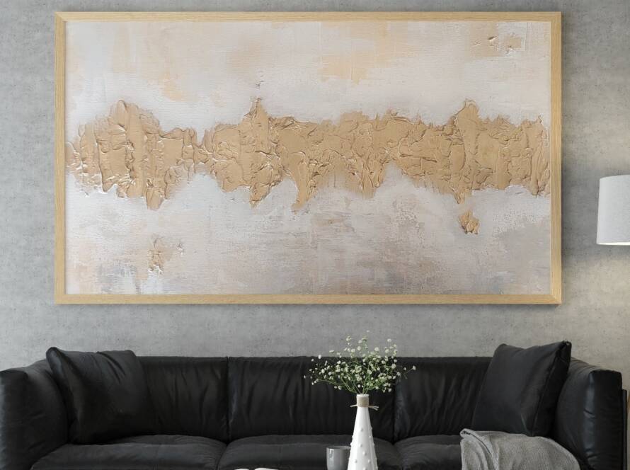 Chaya Koritz's golden abstract painting hangs above a dark gray couch in a modern room.