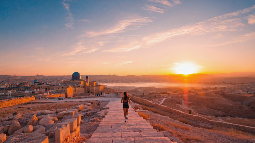 Runner at sunrise with Jerusalem skyline in the background